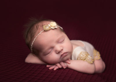 newborn photographer baby girl sleeping on red