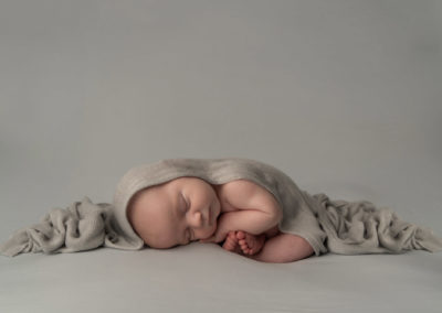 newborn photographer, baby boy sleeping curled up in a grey wrap