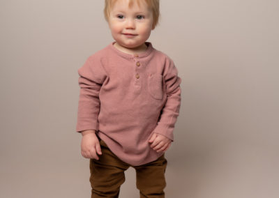 little boy smiling in cute neutral outfit for a Taipei photoshoot with boho baby international