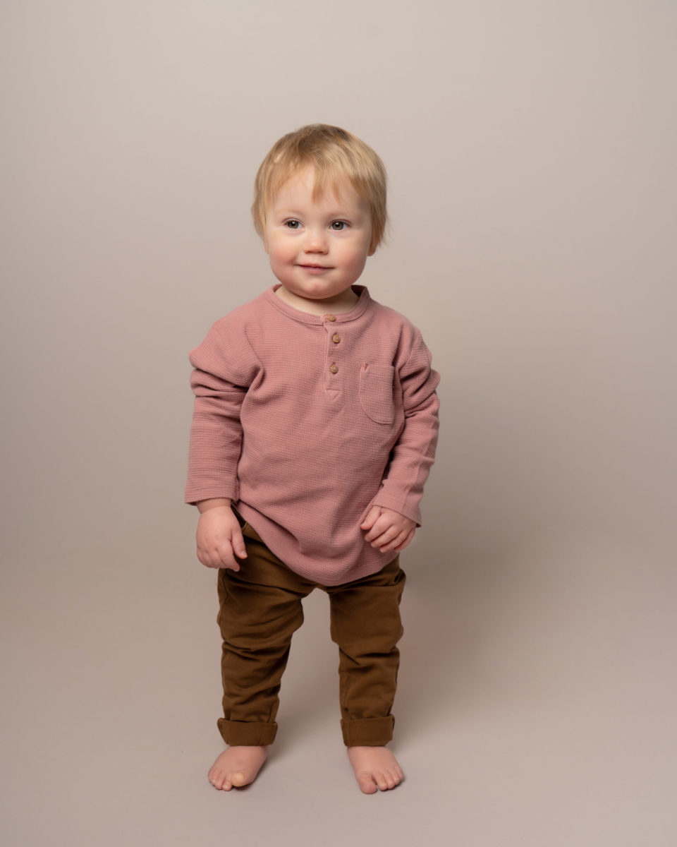 little boy smiling in cute neutral outfit for a Taipei photoshoot with boho baby international